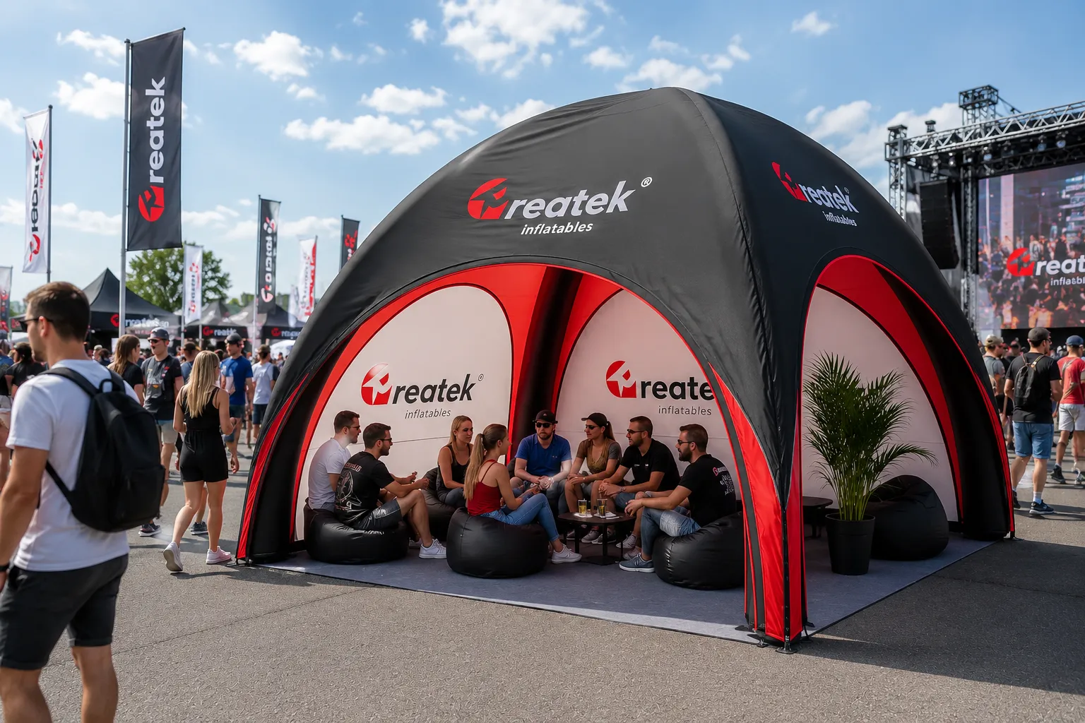 Červeno-čierny pneumatický nafukovací stan REATEK na veľkom brand evente s posedením pre návštevníkov.